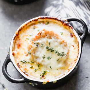 Bowl of French onion soup topped with cheese and thyme